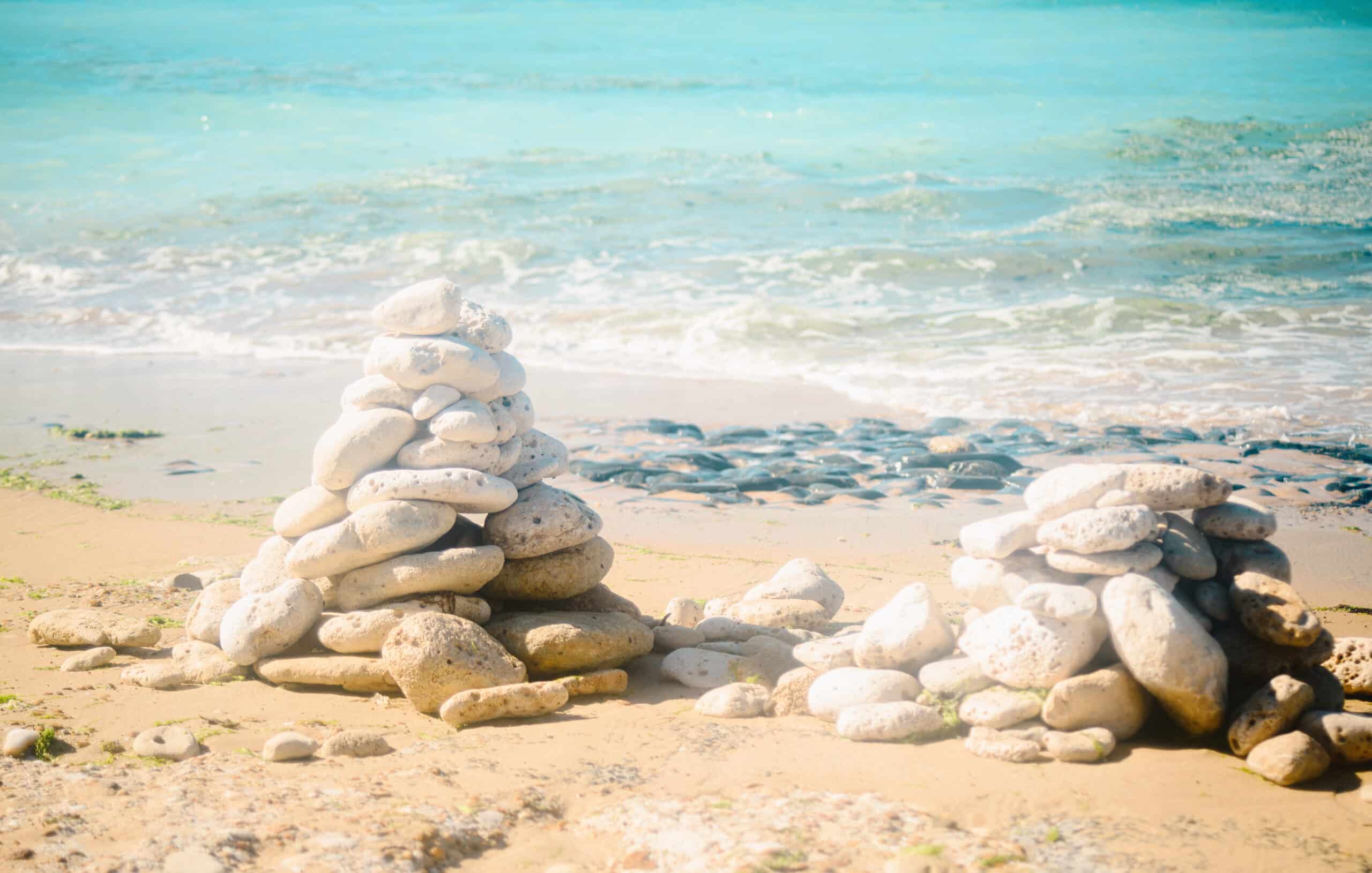 Cairns de pierres sur la plage, mer en arrière-plan.