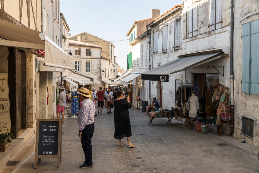 Rue commerçante animée avec boutiques et piétons.
