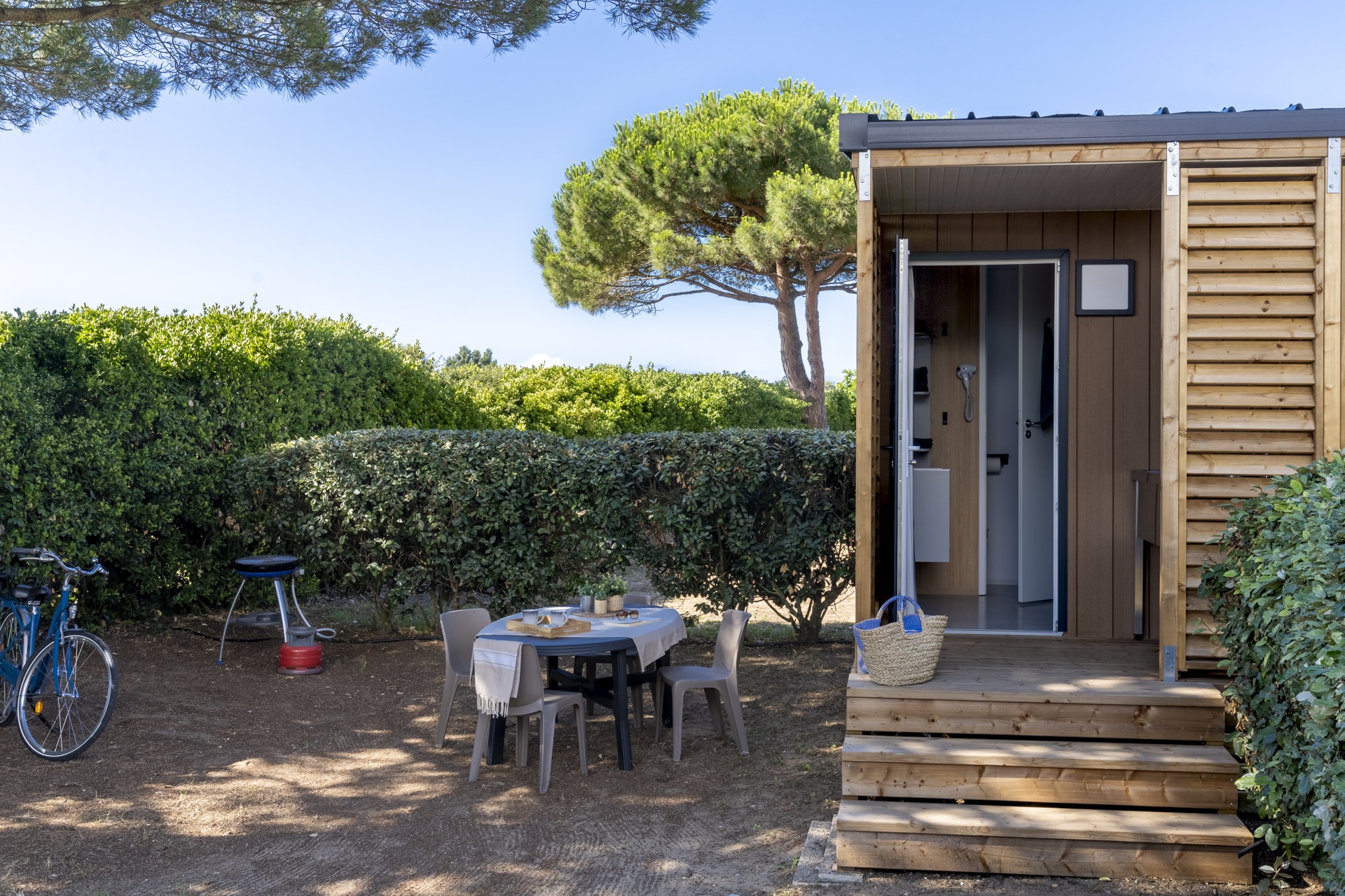 Cabane en bois avec terrasse extérieure et mobilier.